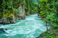 Serene river winding through lush forest gorge, showcasing nature's beauty.
